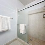 Large walk in shower with glass doors.